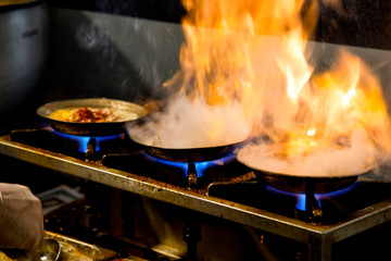 Cooking soup with meat over high heat. Cheff is cooking authentic beyran soup   in flaming pan.