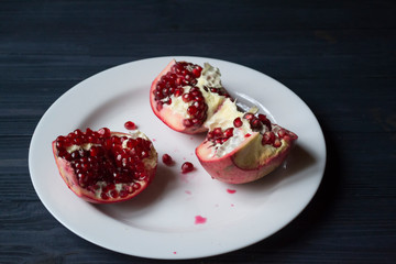 Pomegranate on a white plate. Close up.