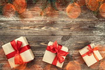Old wood background with fir branches. Holiday Gifts. Christmas card. Top view. Effect of light...