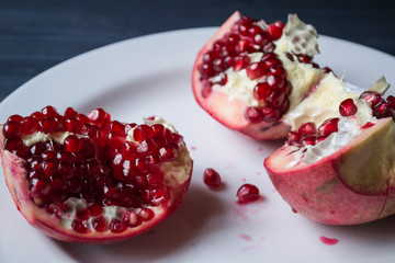 Pomegranate on a white plate. Close up.