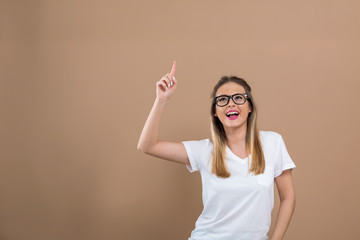 Young woman reaching and looking upwards on a brown background