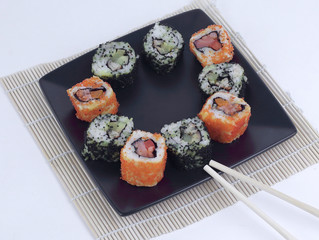 Sushi Set - different types of Maki sushi and chopsticks on a b