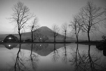 Black and white fumotoppara camp site and dead trees reflections waterfront Fuji mountain background in Japan at night time art style 