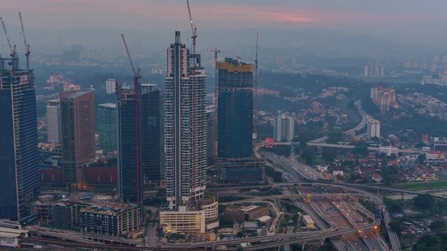 High POV of Kuala Lumpur city skyline during a hazy sunrise. Pan Up