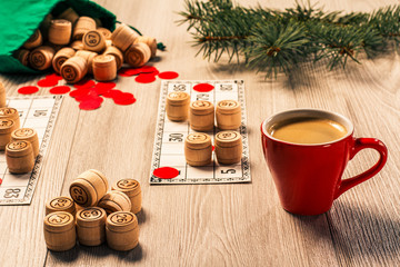 Wooden lotto barrels with bag, game cards, red chips and cup of coffee