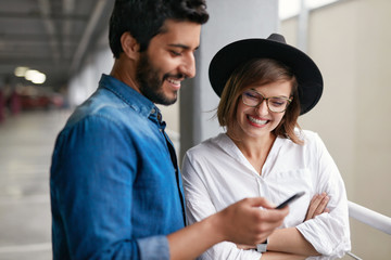 Portrait Of Smiling Couple With Mobile Phone Indoors