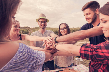 group of friends build a stack with their hands to symbolize togetherness