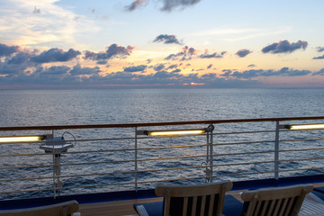 View from the deck of the cruise ship to the ocean. Sea horizon, clouds, blue tropical sky