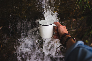 Crop hand taking water from water source