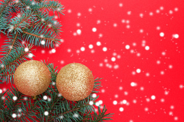 Christmas and New Year background. Golden ball and branches of the Xmas tree on a red background. Copy space.