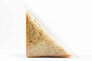 Whole wheat sandwich toast with ham and cheese in a plastic box isolated on white background