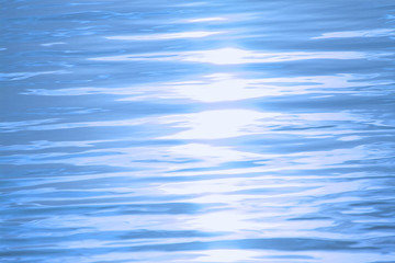 water surface with ripples and waves. sun glare. aquatic background. tinted