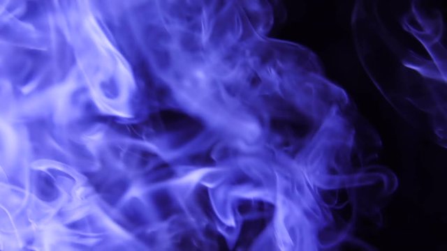 Blue Steam Rises from up. Blue smoke over a black background. Smoke slowly floating through space against black background. Slow Motion.