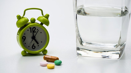 Clock  Green with medicine for various diseases ,Concept take medication on time.