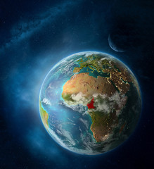 Cameroon from space on Earth surrounded by space with Moon and Milky Way. Detailed planet surface with city lights and clouds.