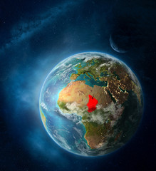 Chad from space on Earth surrounded by space with Moon and Milky Way. Detailed planet surface with city lights and clouds.
