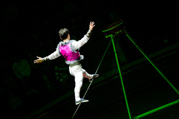 Acrobat walking on a rope during a performance in the circus