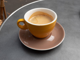 Yellow Coffee Cup on Brown Plate on a Dark Table