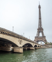 View of the Eiffel Tower From the River Next to Large Bridge
