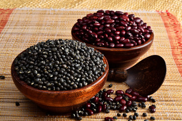 raw uncooked pulses, kidney beans and urad daal on wooden placemats,