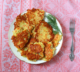 potato pancakes with dill on a red background
