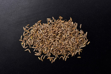 cumin seeds on black textured background , jeera spice