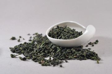 Chinese green tea in tea ware. Infusions. Heap of dry tea leaf.