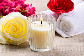 Obraz na płótnie Canvas white candle with yellow flower on wooden background, scented candle, spa composition.