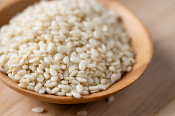 White sesame seeds in a wooden spoon