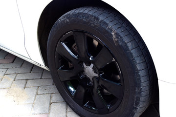 Obraz premium black alloy wheel on white car , automobile concept