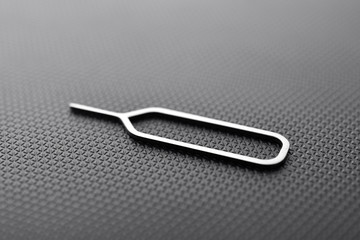 sim ejector tool on black textured background