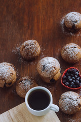 A cup of coffee with cookies on a wooden table.