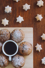 A cup of coffee with cookies on a wooden table.