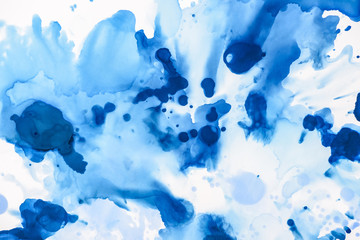 Fototapeta na wymiar blue and light blue splashes of alcohol ink on white as abstract background