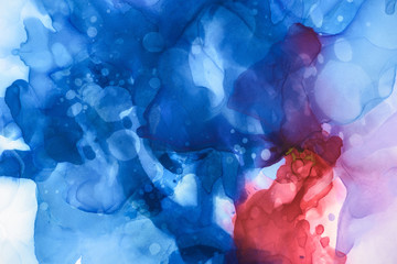blue, red and violet splashes of alcohol inks as abstract background