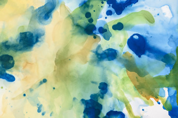 yellow, green and blue splashes of alcohol inks as abstract background