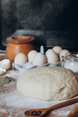 Raw dough with butter, flour and eggs on wooden table