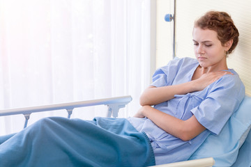Beautiful young woman patient with neck pain on hospital bed room.Copy space.