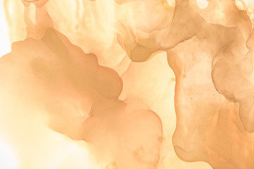 beige splashes of alcohol ink as abstract background