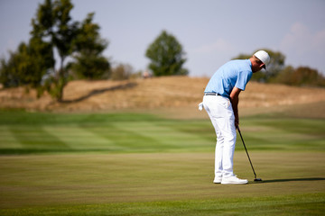 Professional golfer on putting green.