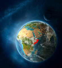 Somalia from space on Earth surrounded by space with Moon and Milky Way. Detailed planet surface with city lights and clouds.