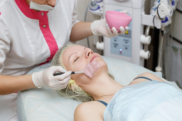 Obraz na płótnie Canvas Woman getting face peeling mask in spa beauty salon