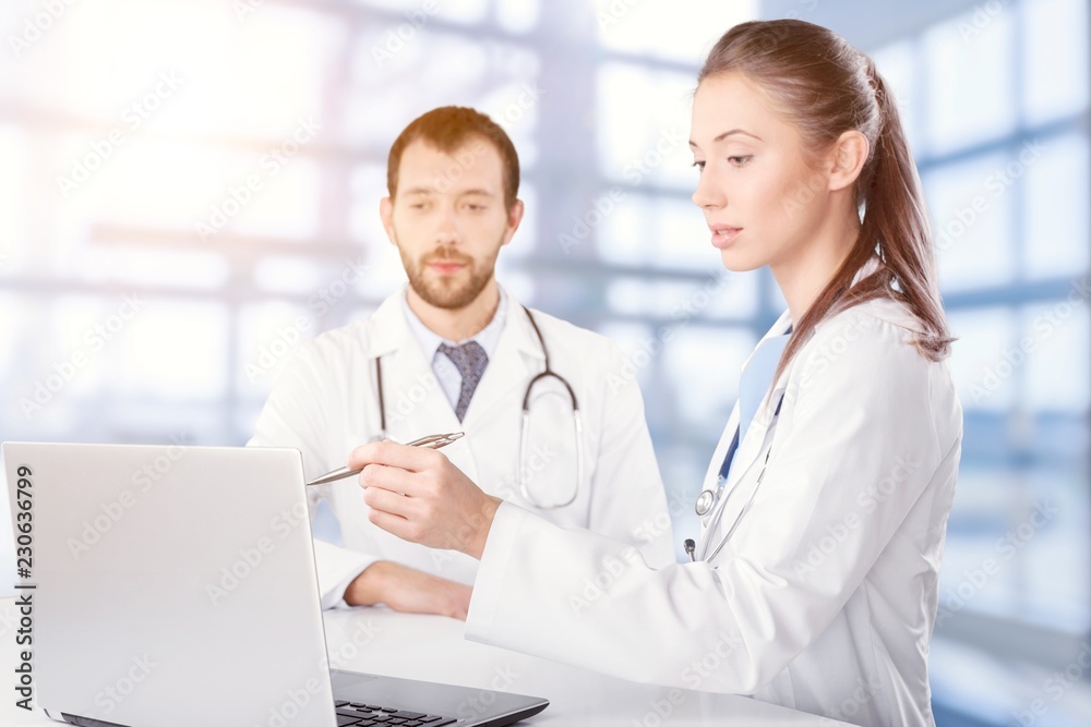 Wall mural Female and male scientists in glasses working with microscope