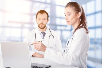 Fototapeta premium Female and male scientists in glasses working with microscope