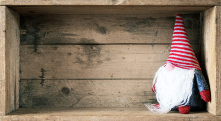 Christmas decoration with a gnome in a wooden box background