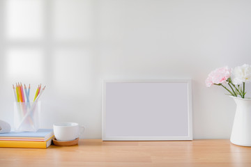 Mock up protrait photo frame with flowers on table
