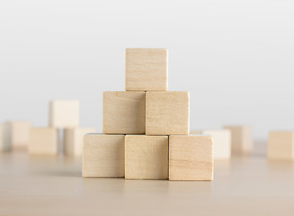 Wooden blocks stacking as a pyramid staircase on white background. Success, growth, win, victory, development or top ranking concept.