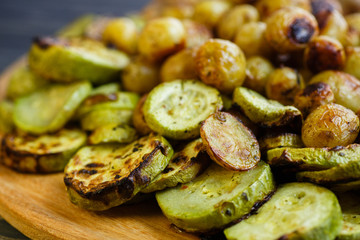 Grilled vegetables and chicken wings on the wooden plate