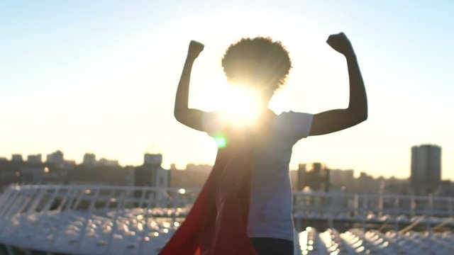 Woman showing success gesture, enjoying cityscape, superpower inspiration