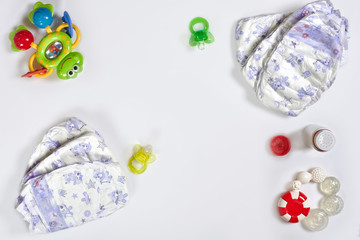 Babies goods diaper, soother or nipple on white background with copy space. Top view or flat lay.